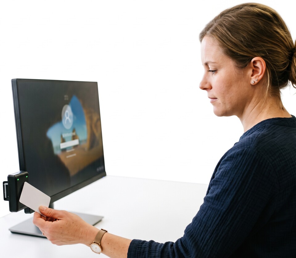 Recepční na malé klinice přikládá přístupovou kartu ke čtečce vedle monitoru a přihlašuje se do Windows